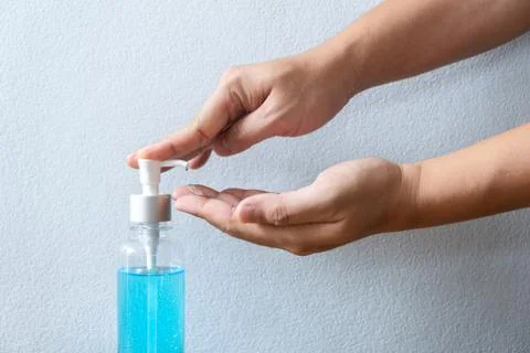 Image of hands using alcohol gel hand sanitizer in pump bottle washing cleani Stock Photos