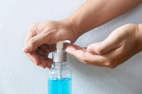 Image of hands using alcohol gel hand sanitizer in pump bottle washing cleani Stock Photos