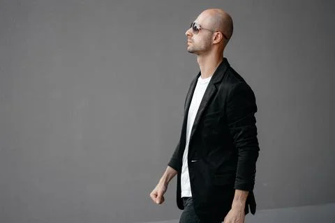 Image of a handsome bald man in a white T-shirt on a gray background Stock Photos