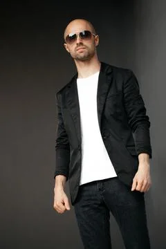 Image of a handsome bald man in a white T-shirt on a gray background Stock Photos