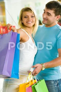 Image of handsome man looking at his beautiful girlfriend in the shopping mall Stock Photos