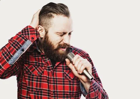 Image of a handsome man singing to the microphone. Stock Photos