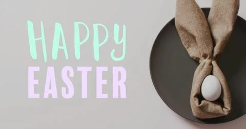 Image of happy easter text over easter eggs in cloth on white background Stock Photos