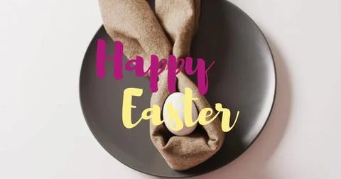 Image of happy easter text over white easter egg in cloth on black plate on Stock Photos