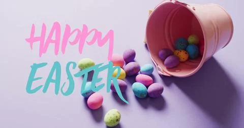 Image of happy easter text over colourful easter eggs on purple background Stock Photos