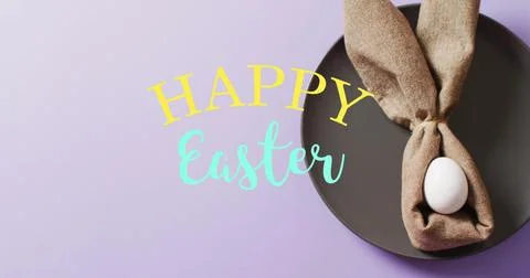 Image of happy easter text over white easter egg in cloth on purple background Stock Photos