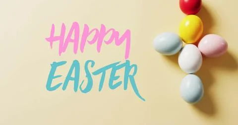 Image of happy easter text over colourful easter eggs on yellow background Stock Photos