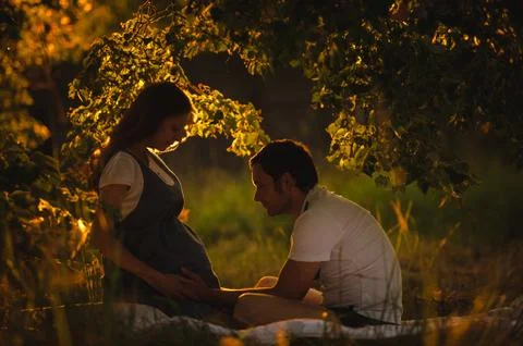 Image of happy future dad touching the belly of his pregnant wife Stock Photos
