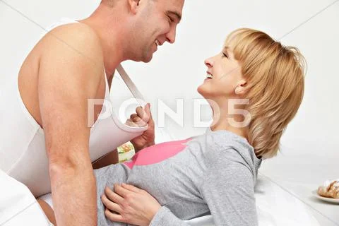 Image of happy passionate woman pulling a man for his t-shirt to herself Stock Photos