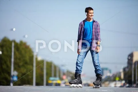 Image of happy teenager on roller skates in the city Stock Photos