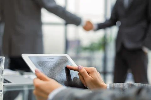 Image of human hands during discussion of paper and electronic documents at.. Foto stock