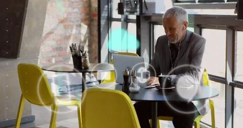 Image of icons and data processing over caucasian businessman using laptop Stockfoto's