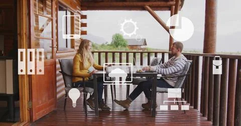 Image of icons and data processing over biracial couple at table on terrace Stock Photos