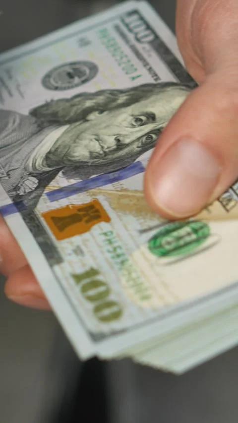 In the image, an individual is seen meticulously arranging stacks of Stock Footage 279218804