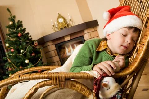 Image of innocent child having a snap on rocking chair on xmas evening Stock Photos