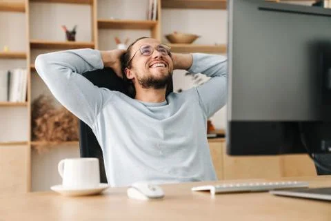 Image of joyful programmer man resting while working with computer Stock Photos