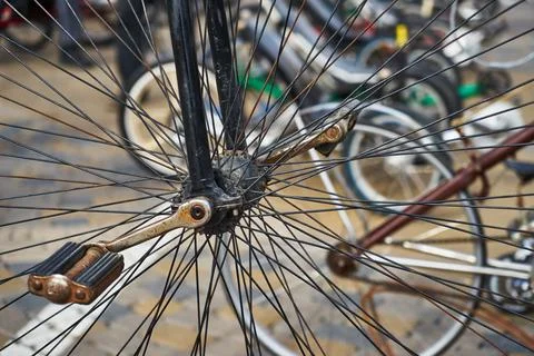 An image of a large old-fashioned bicycle wheel and pedals. Stock Photos