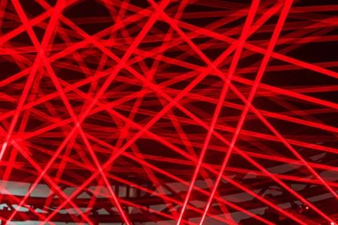 Image of a laser show featuring geometric red patterns suspended above a gray Stock Photos