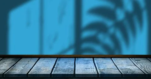 Image of leaves and window shadow over blue and wooden background Stock Photos