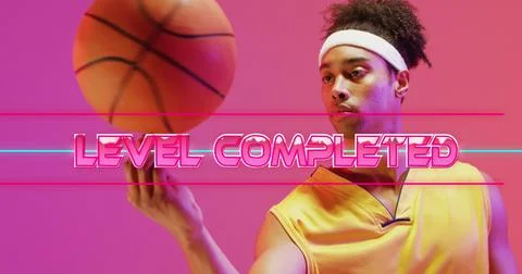 Image of level completed text over neon pattern and biracial basketball player Stockfoto's