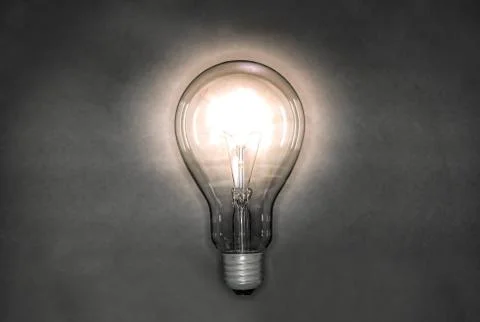 Image of a light bulb emitting light in a night background Stock Photos