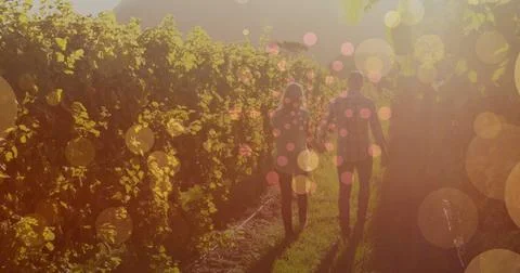 Image of light spots over caucasian couple walking and holding hands Fotos Stock
