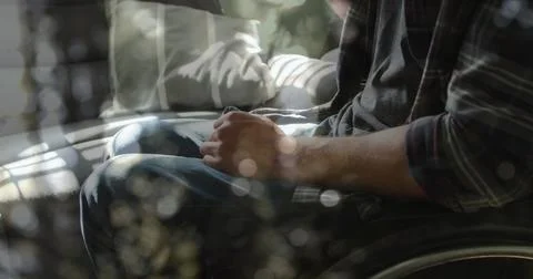 Image of light spots over disabled caucasian man sitting in wheelchair Ilustração Stock