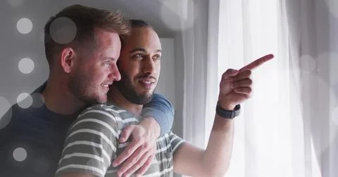 Image of light spots over diverse male couple embracing Ilustração Stock