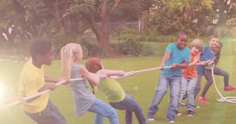 Image of light spots over diverse schoolchildren pulling line in park Ilustración de archivo