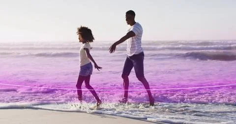 Image of light trail over african american couple at beach Fotos Stock