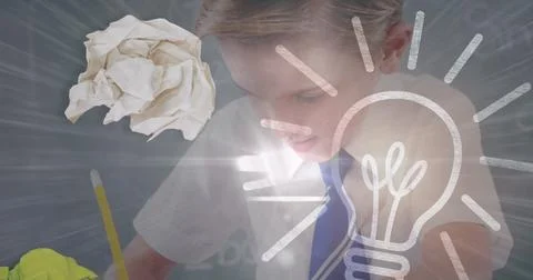 Image of lit light bulb over schoolboy writing in class in background Ilustração Stock