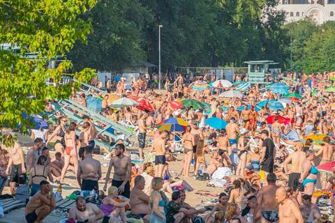 Image of a lively public pool or beach area with people enjoying around col.. 스톡 사진