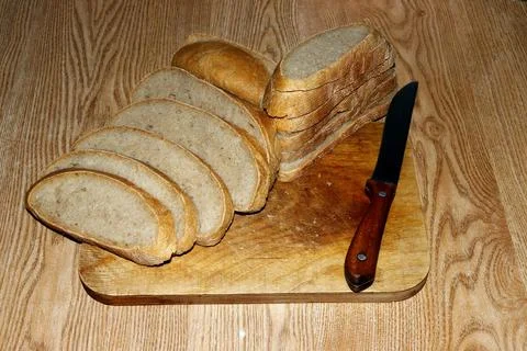Image of a loaf of bread cut into slices on a kitchen board. Foto stock