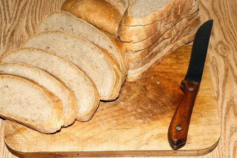 Image of a loaf of bread cut into slices on a kitchen board Stock Photos