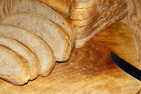 Image of a loaf of bread cut into slices on a kitchen board Stock-Fotos