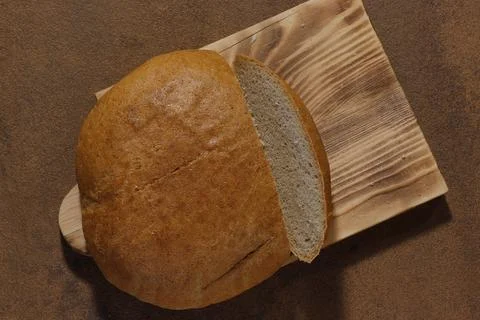 Image of a loaf of bread cut into slices on a kitchen board. Stock Photos