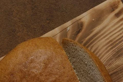 Image of a loaf of bread cut into slices on a kitchen board. Stock Photos