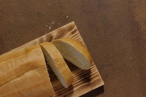 Image of a loaf of bread cut into slices on a kitchen board. Stock-Fotos