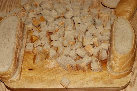 Image of a loaf of bread cut into slices on a kitchen board. Stock Photos