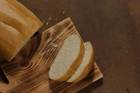 Image of a loaf of bread cut into slices on a kitchen board Stock Photos