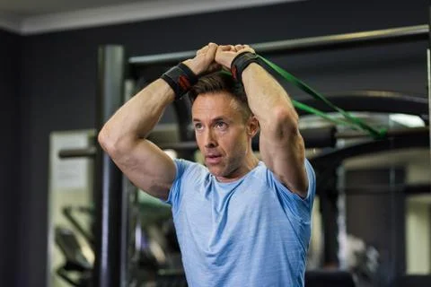 Image of man doing exercise with elastic band at the gym. Stock Photos