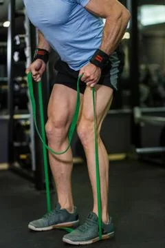 Image of man doing exercise with elastic band at the gym. Stock Photos