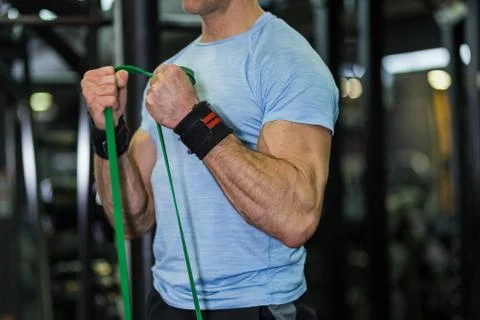 Image of man doing exercise with elastic band at the gym. Stock Photos