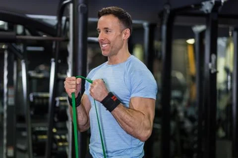 Image of man doing exercise with elastic band at the gym. Stock Photos