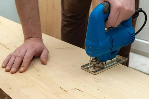 Image of a man hand using electric jigsaw Stock Photos