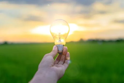 Image of a man holding a light bulb in his hand Stock Photos