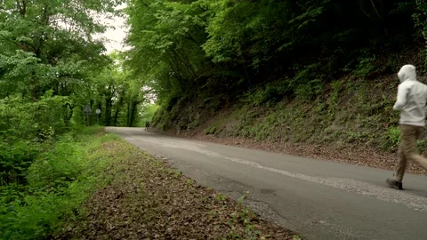 Image of a man jogging alone at calm road surrounded by forest, Croatia. Video stock 132725955