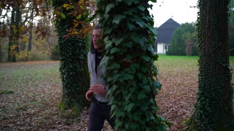 Image of man running between trees at public park, Zagreb, Croatia. 動画素材 102547471