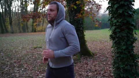 Image of man running between trees at public park, Zagreb, Croatia. Stock Footage 102550048