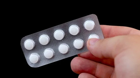 Image of man taking pill out from blister pack at home. We take the tablets with Stock Footage 90964017